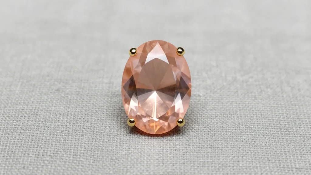 oval peach morganite solitaire on soft gray linen