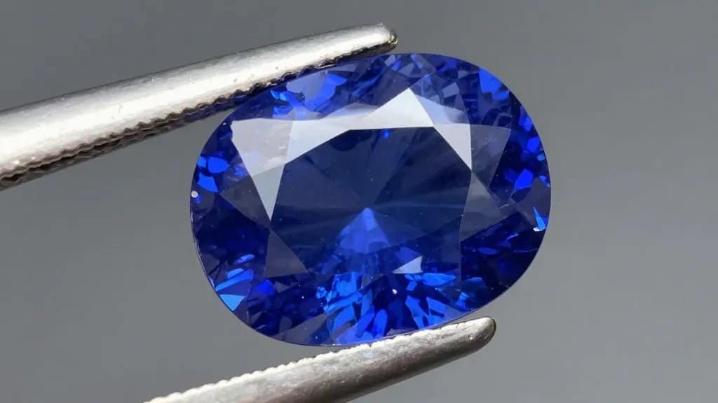 vivid royal-blue sapphire solitaire under gem loupe, closeup