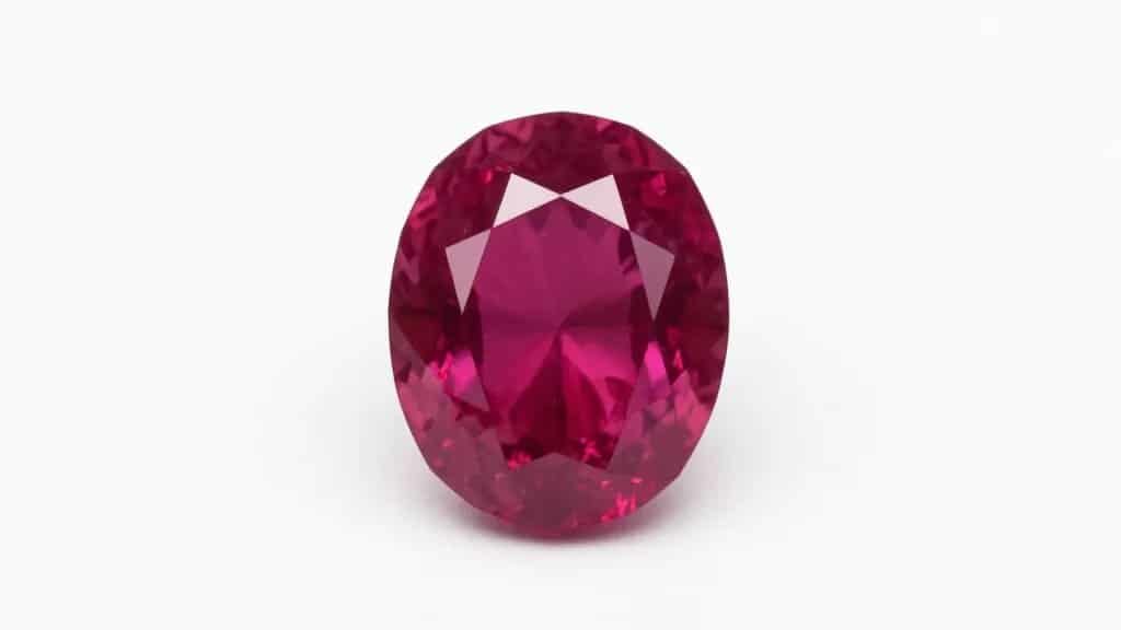 Single ruby on white background, vivid pigeon-blood hue