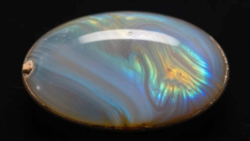 Ammolite cabochon showing vivid iridescent bands, macro shot