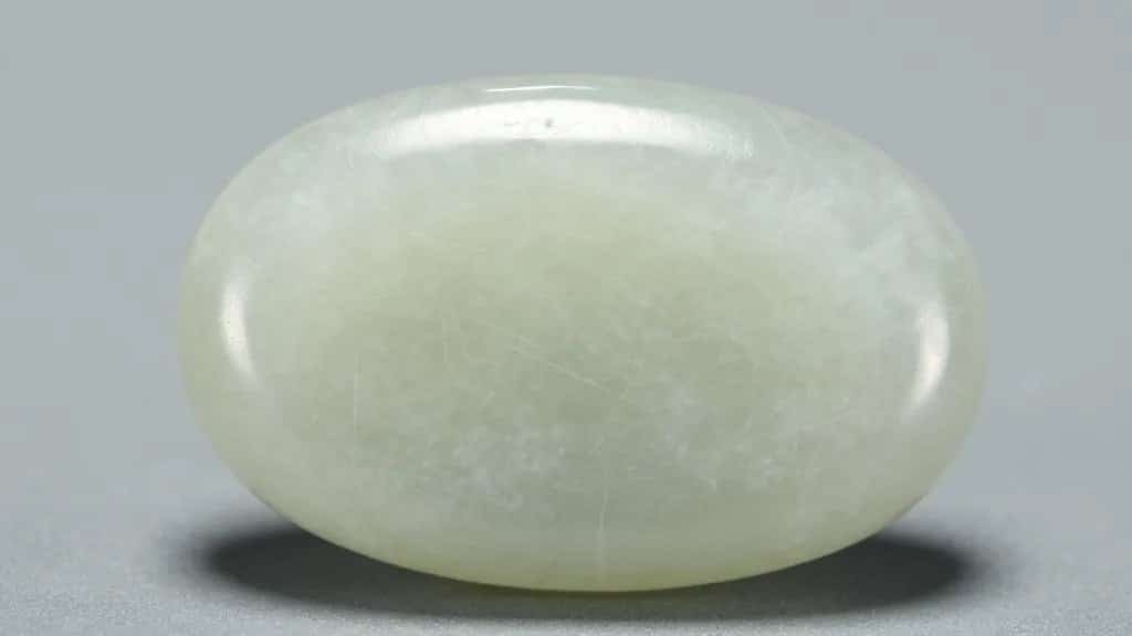 closeup of a single jadeite cabochon with visible fibrous texture