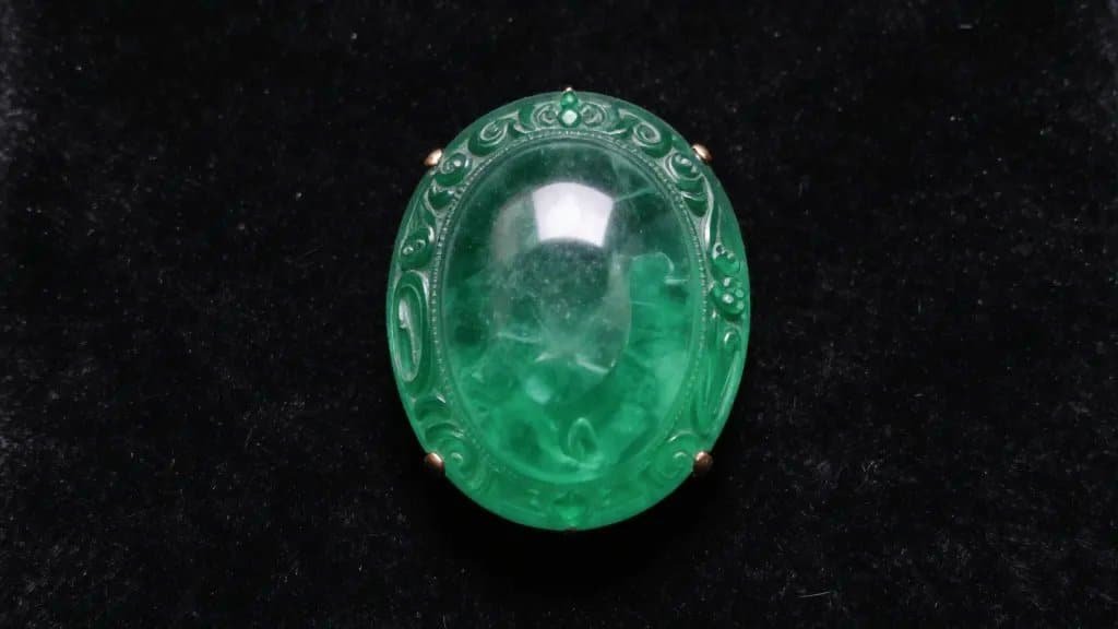 Closeup Mughal-carved emerald cabochon on black velvet