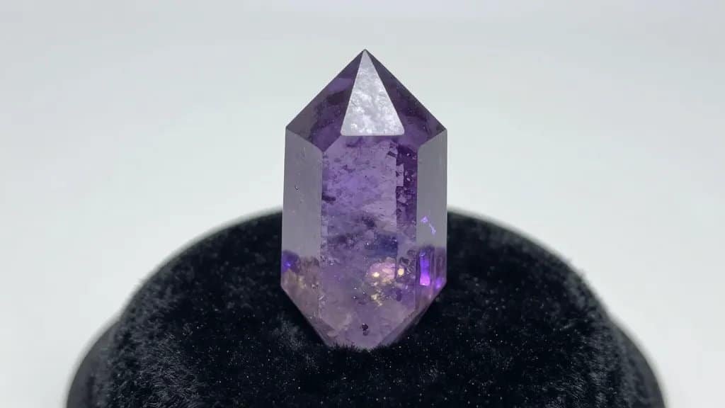 closeup neon tourmaline crystal on black velvet