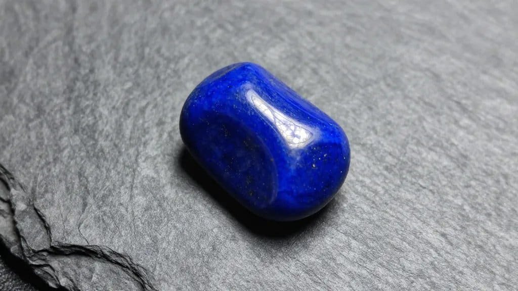 single tumbled blue lapis lazuli on gray slate