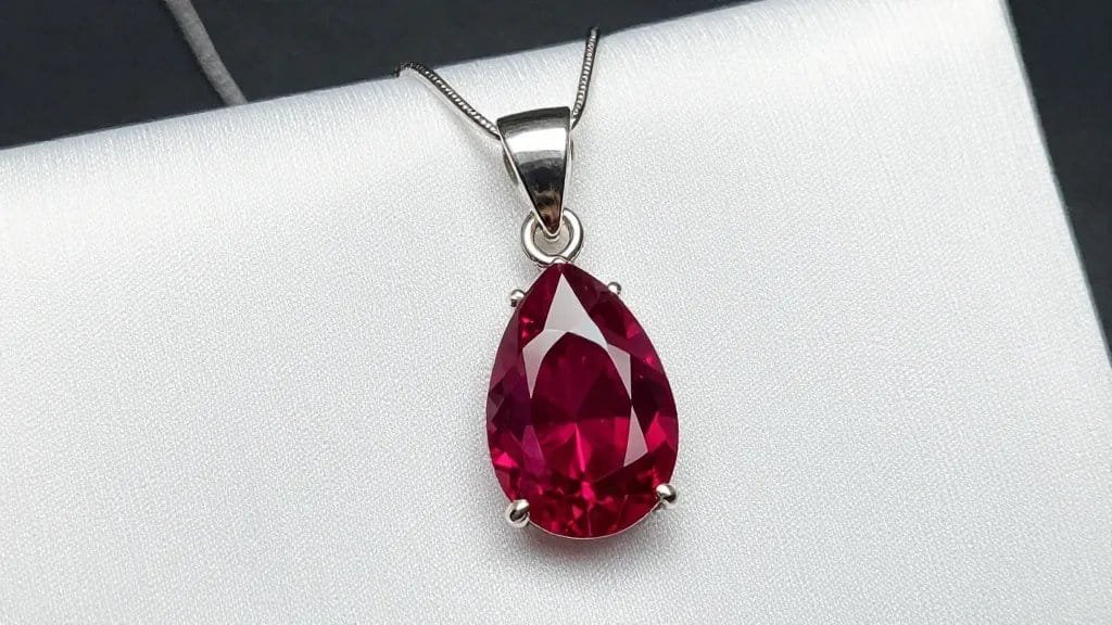 single pear-cut ruby pendant on white silk