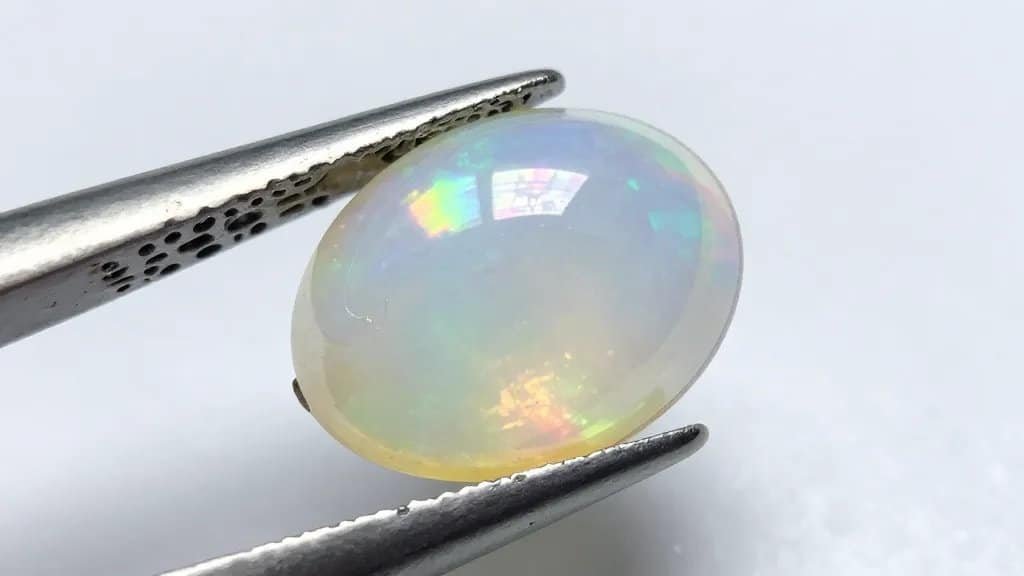 single white opal cabochon showing rainbow play-of-color