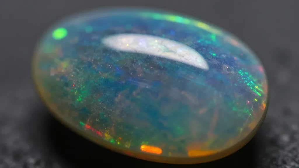 Macro shot of black opal flashing neon rainbow play-of-color