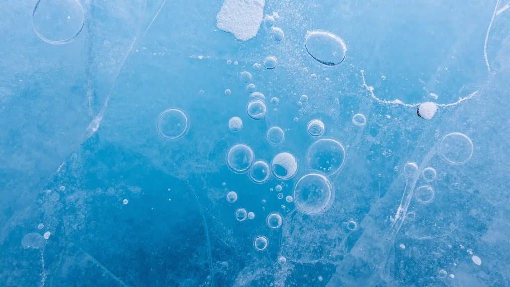 macro shot of blue glacial ice with trapped bubbles