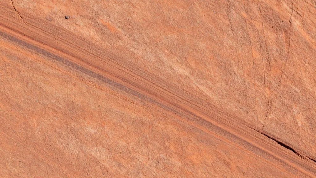 macro of desert varnish streak on sandstone slab