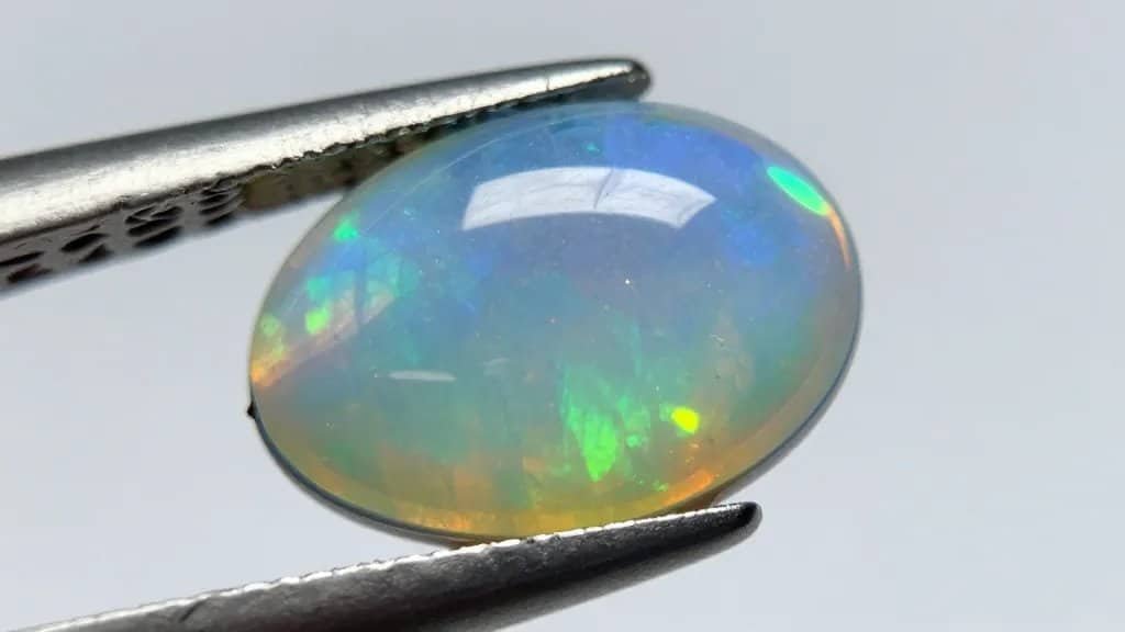 closeup Ethiopian opal cabochon, neon play-of-color